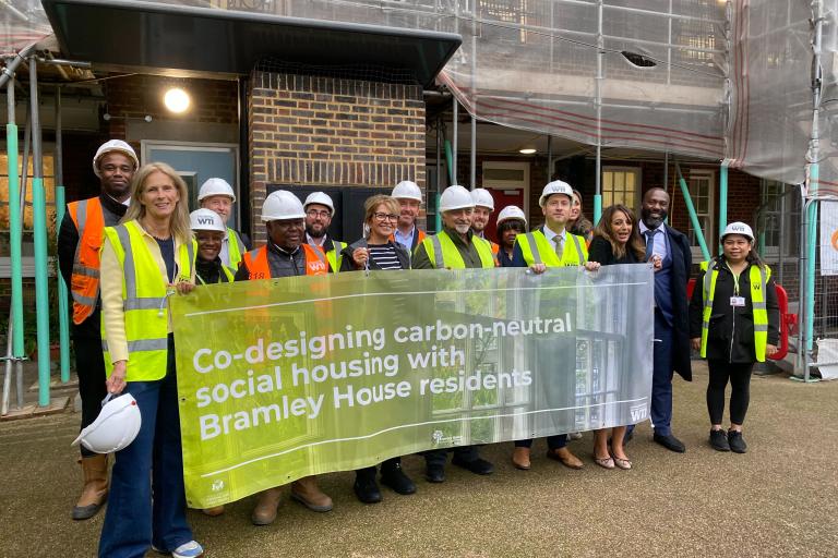 A group of residents, council staff and contractors stand outside Bramley House celebrating the work