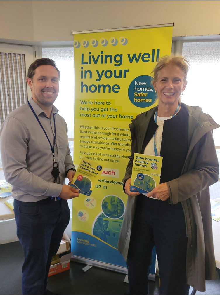 white male holding booklet standing next to white female holding booklet