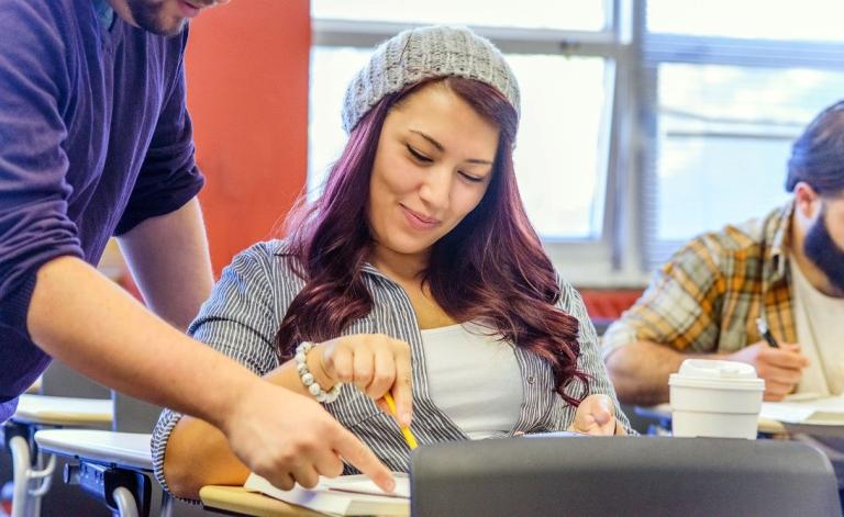 Student receiving support from a tutor in a classroom
