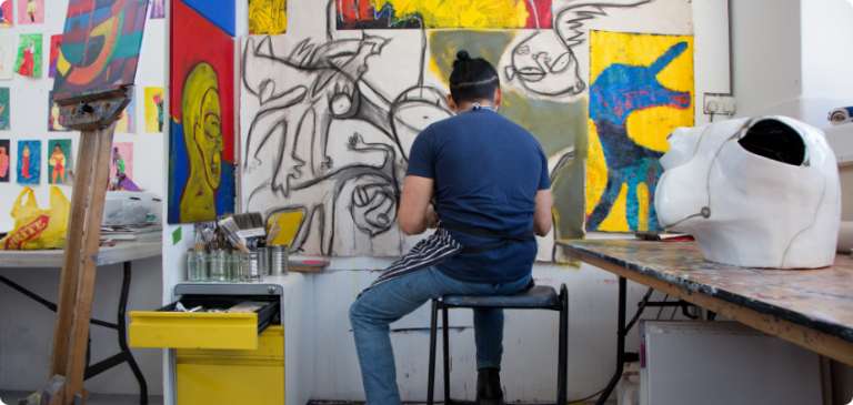 Artist working on a large painting in studio