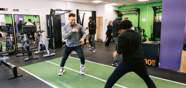Two people taking part in a fitness session at a community gym