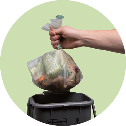 Bag of food waste being put into a recycling bin